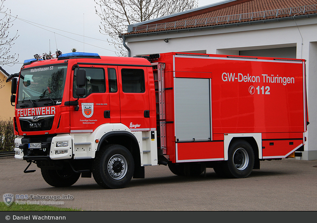 Roter Feuerwehrwagen aus Thüringen, geparkt vor Gebäude.