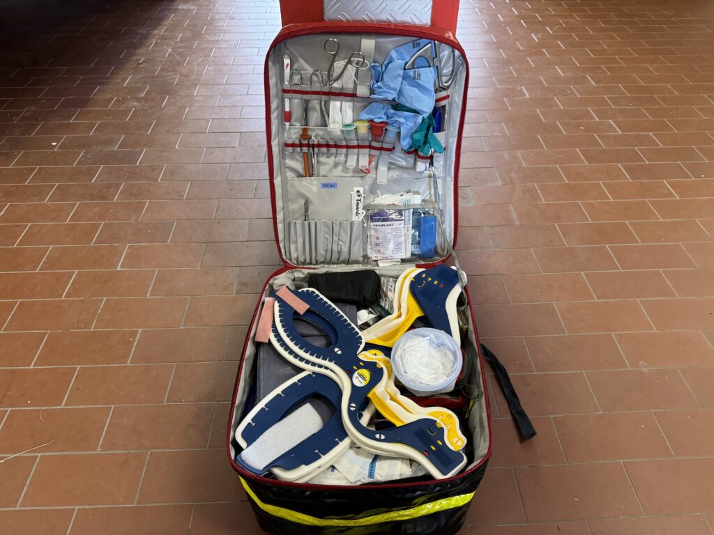 Offener Erste-Hilfe-Koffer auf Fliesenboden